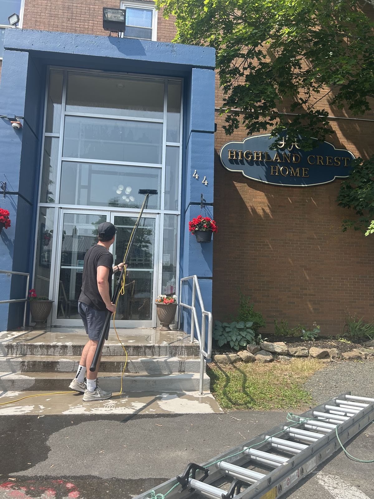 Crew member cleaning the entrance windows at Highland Crest Home